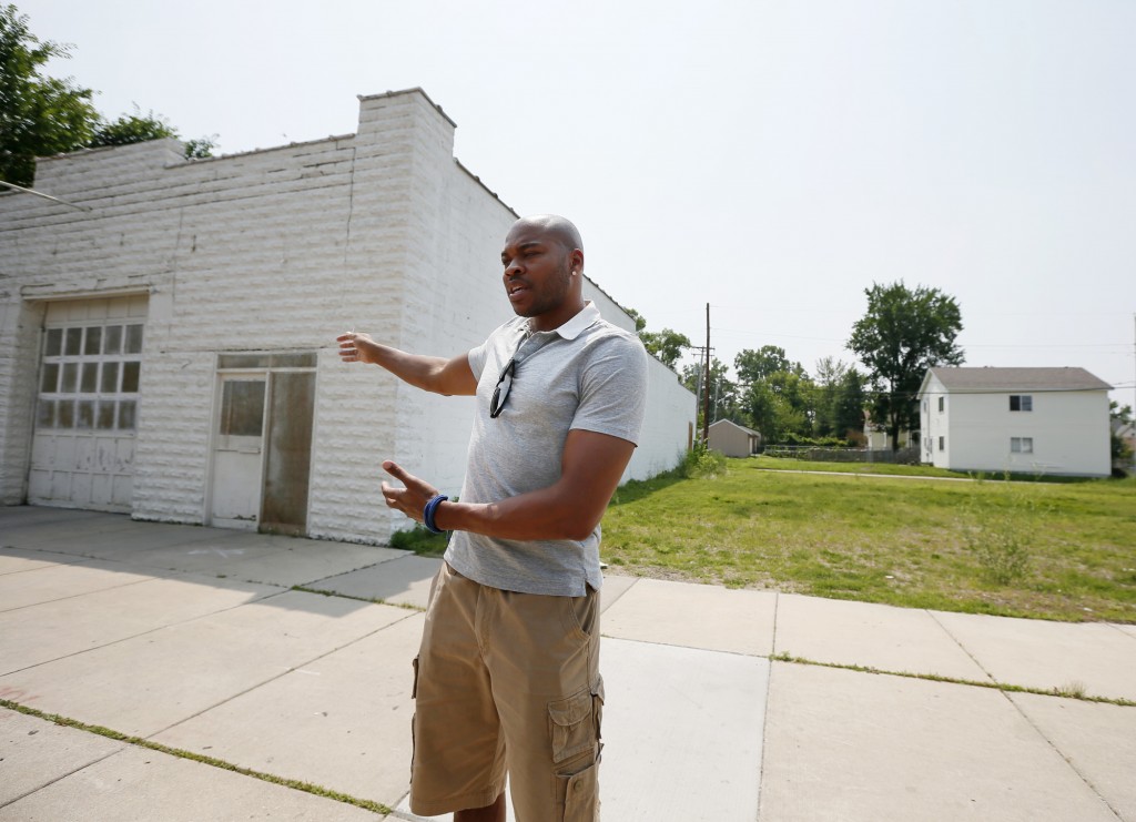 Devean George '99 gestures toward an abandoned building