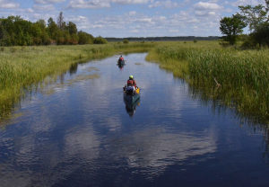 Students canoeing in two canoes on the river