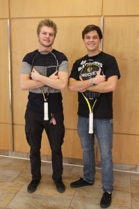 Two students hugging their tennis rackets.