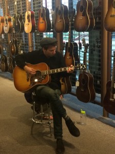 Nick playing guitar in a guitar store.