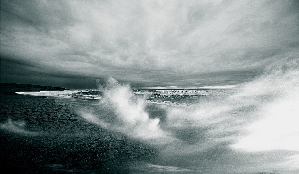 Gloomy photo of waves crashing on the shore.