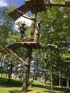 Two StepUP Counselors standing on a wooden platform attatched to a pole. 