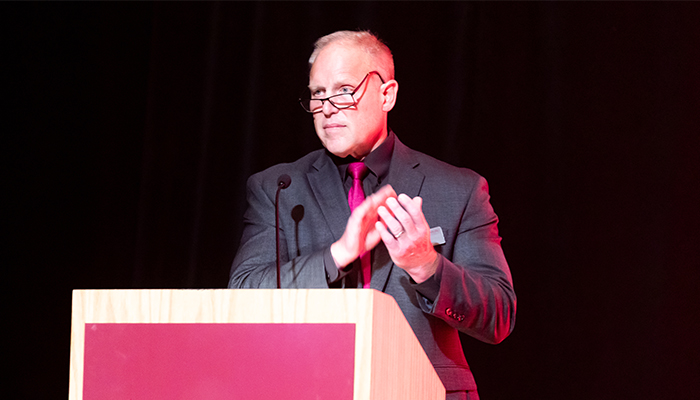 A person presenting at an awards ceremony.