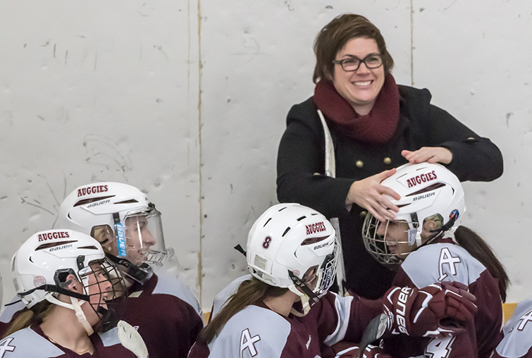 Women's Hockey coach Michelle McAter congratulates players during a 2016-17 season game against St. Olaf.
