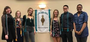 Six students newly inducted into AKD pose together, wearing their new AKD graduation cords over their shoulders.
